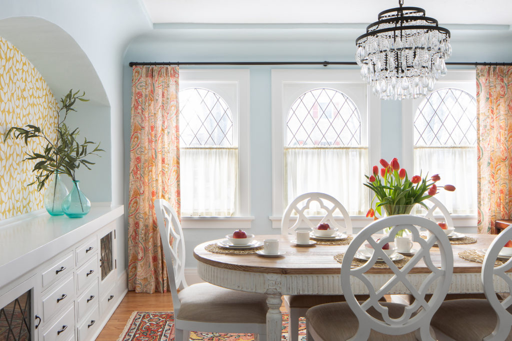 A great example showing how the wallpaper in this 1920s home shows off the curved archway over antique built-ins.