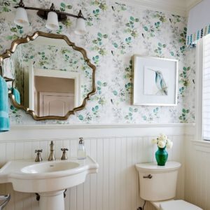 Interior designer Kathy McGroarty brought a cottage feel to this small bathroom with a combination of beadboard trim and pretty floral wallpaper.
